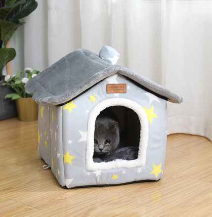 Covered Pet Cave Bed – cat peeking out from a gray pet house with star patterns on a wooden floor