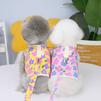 Floral Dog Harness & Leash – two small dogs wearing colorful floral harnesses on a white surface