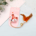 Feather & Bell Cat Toy – cat toy with fox design and feather on a light blue surface