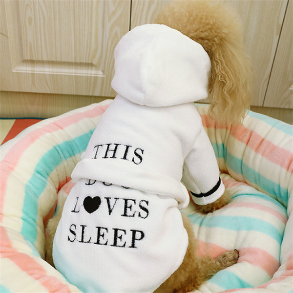 White Hooded Dog Bathrobe – dog wearing the white hooded bathrobe, sitting on a colorful bed