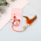 Feather & Bell Cat Toy – cat toy with fox design and feather on a light blue surface